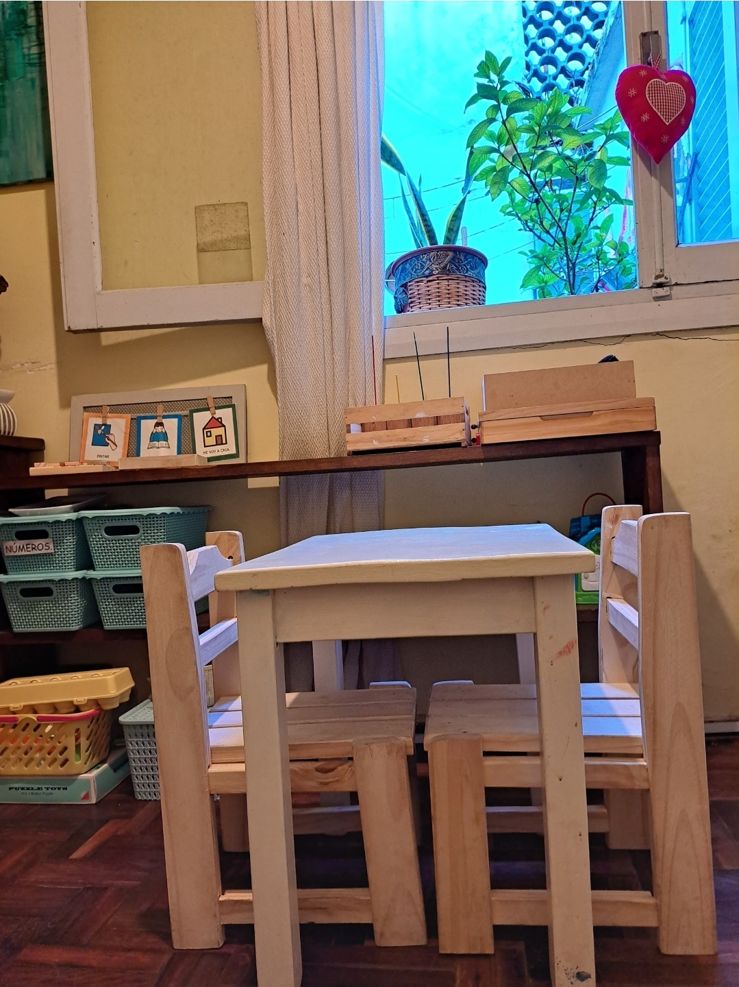 Mesa y sillas de madera adaptadas para trabajo con niños, con pictogramas y materiales organizados