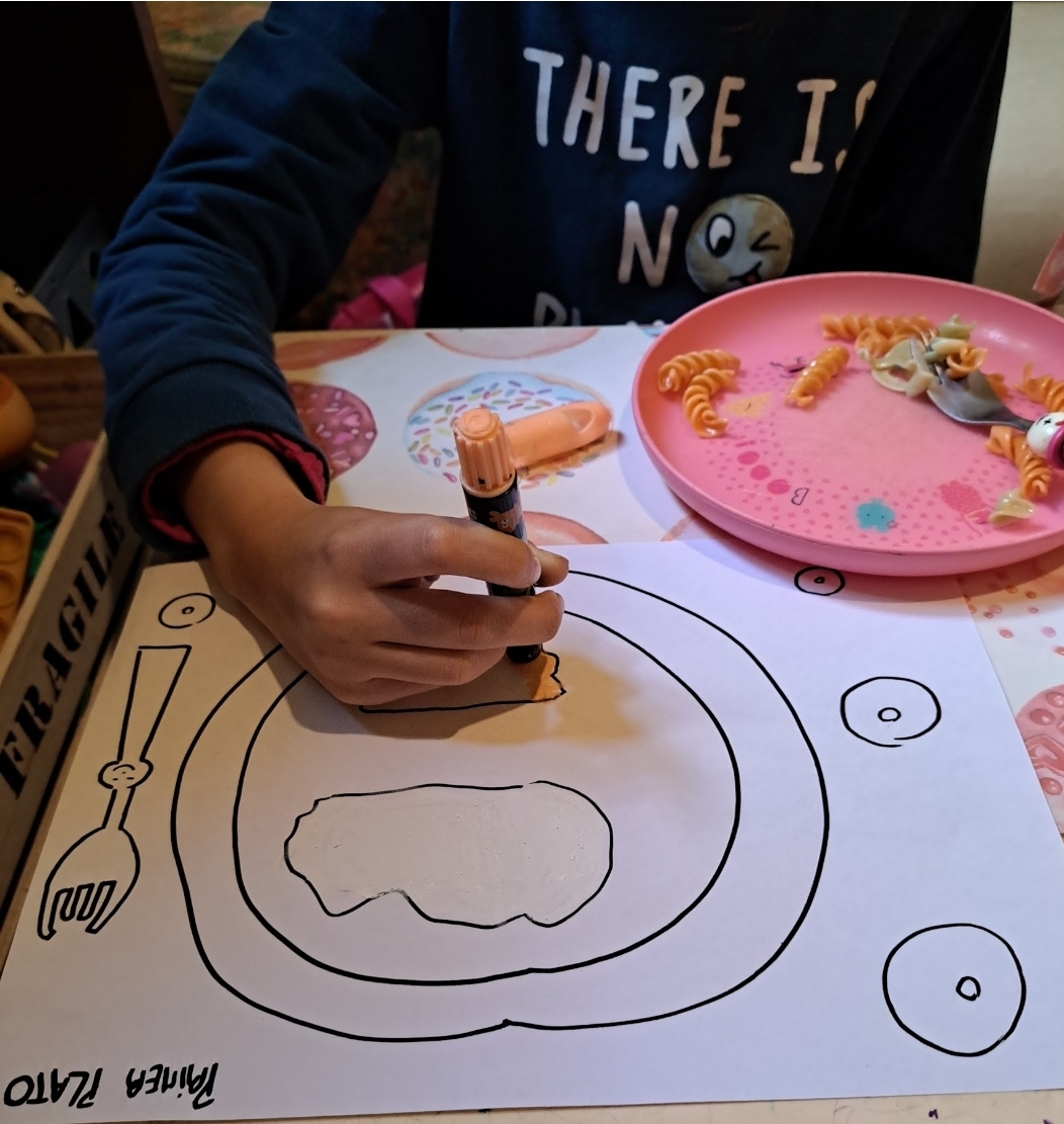 Niño dibujando con marcadores durante actividad terapéutica en sesión presencial